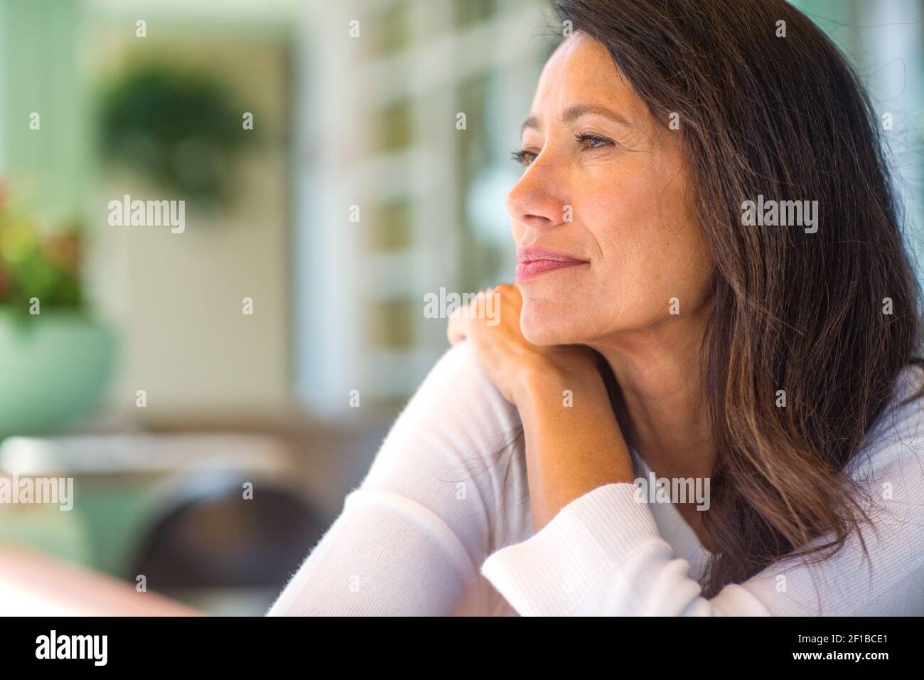 Portrait of a beautiful mature woman sitting on the sofa Stock Photo ...