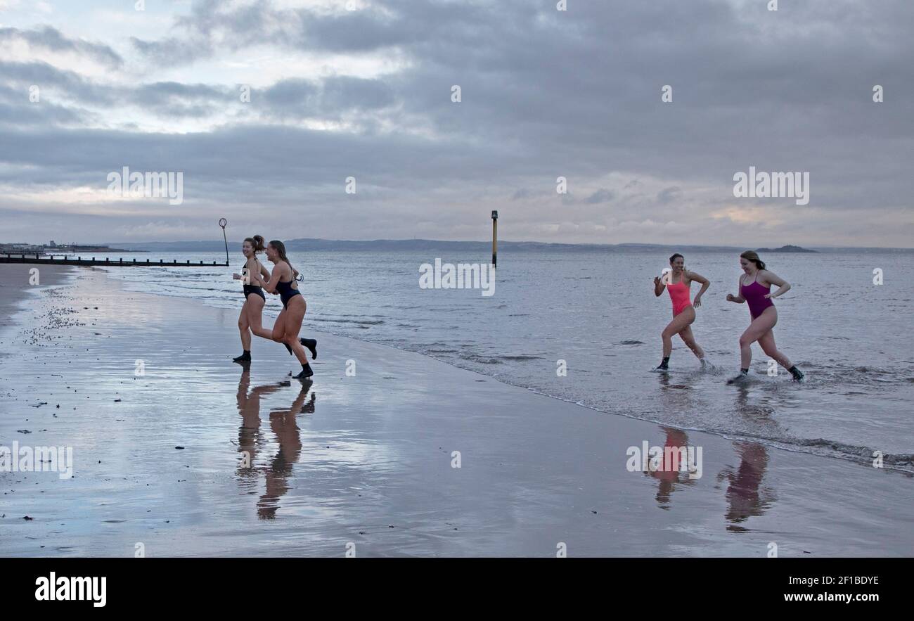 International Women's Day  (IWD)- 8th  March 2021.Portobello, Edinburgh, Scotland, UK. Small groups of women took a dip to mark IWD, different from 2020 when 300 plus women arrived at the seaside. Pictured: Edinburgh University students enjoying the chilly dawn dip. Stock Photo