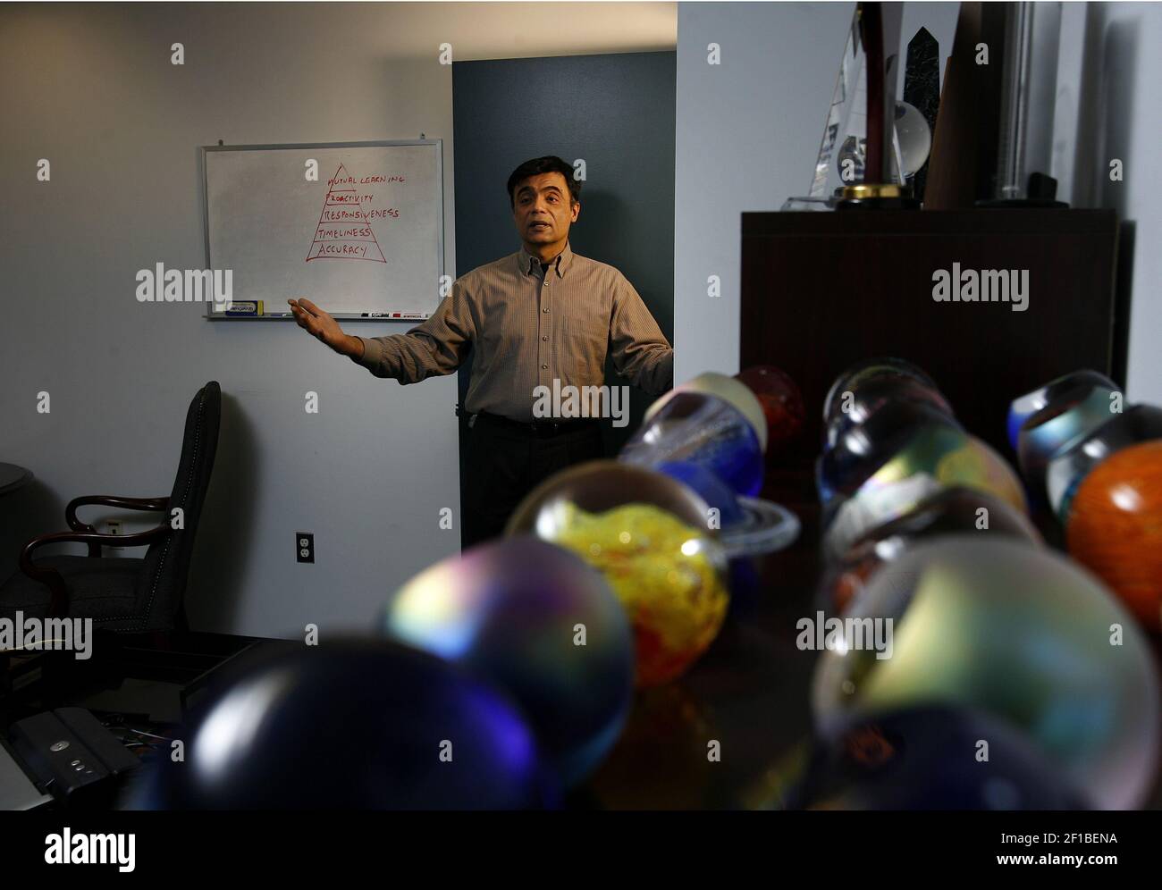 A soldierly lineup of glass balls, foreground, in the office of CEO