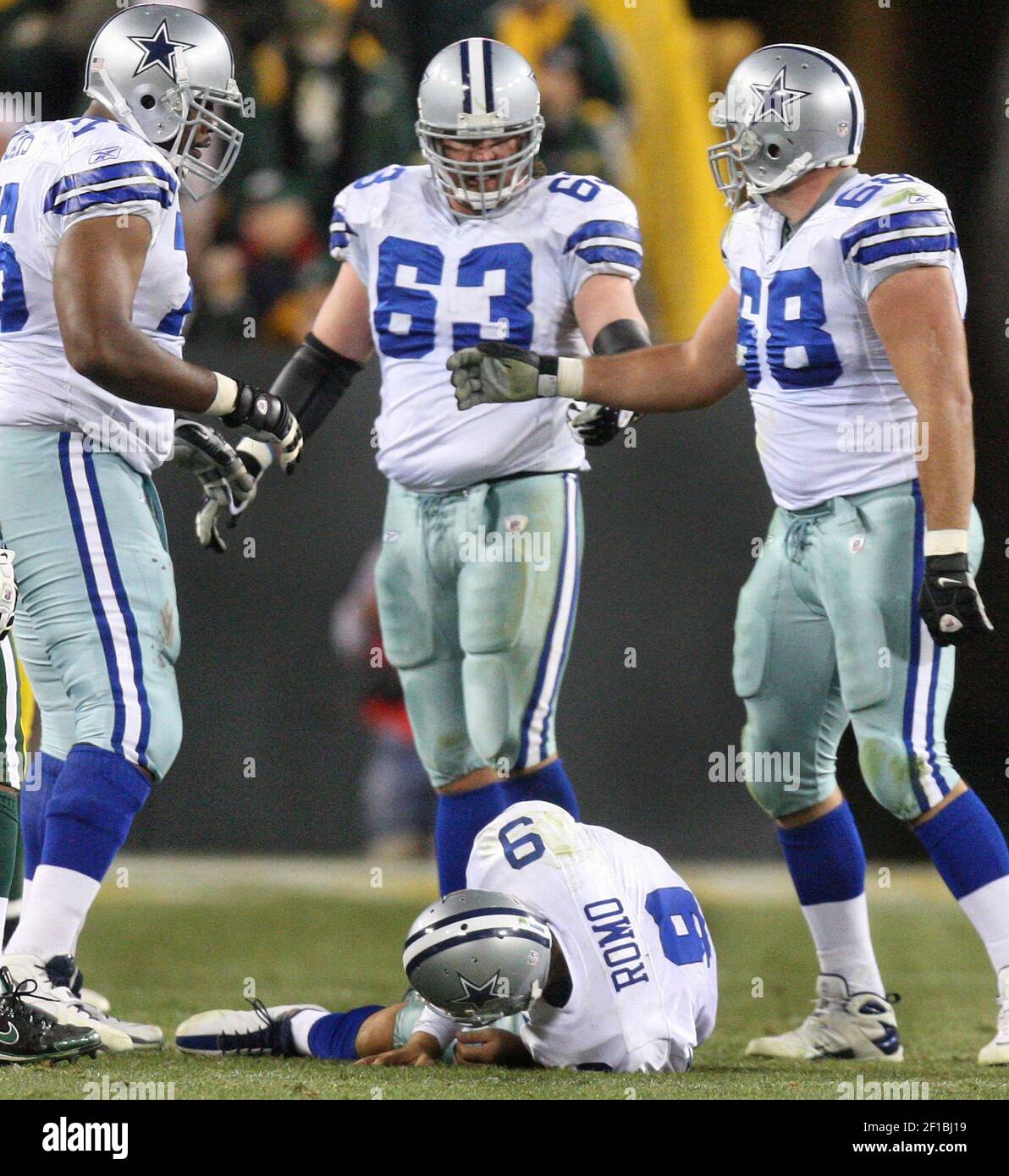 From left, Dallas Cowboys Flozell Adams, Doug Free (68) and Kyle Kosier (63) stand over their quarterback Tony Romo after a pass play in the fourth quarter against the Green Bay Packers on Sunday, November 15, 2009, at Lambeau Field in Green Bay, Wisconsin. The Packers defeated the Cowboys, 17-7. (Photo by Louis DeLuca/Dallas Morning News/MCT/Sipa USA) Stock Photo