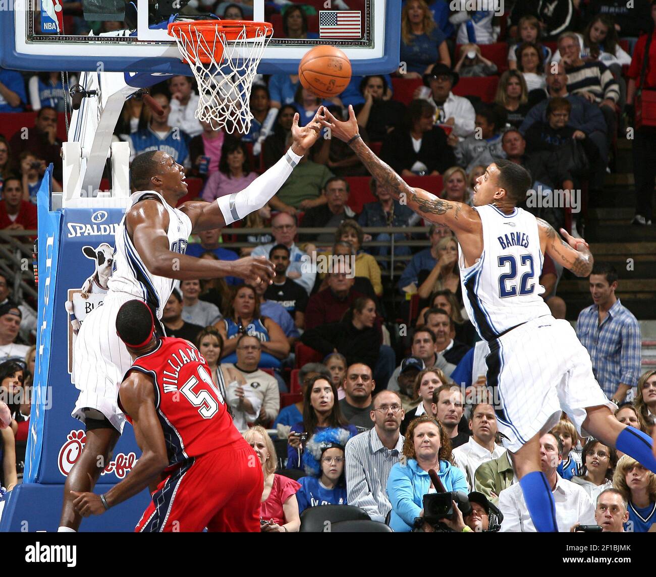 Orlando Magic teammates Dwight Howard left and Matt Barnes 22 stretch for a rebound during the first half against the New Jersey Nets at Amway Arena in Orlando Florida Friday November 13