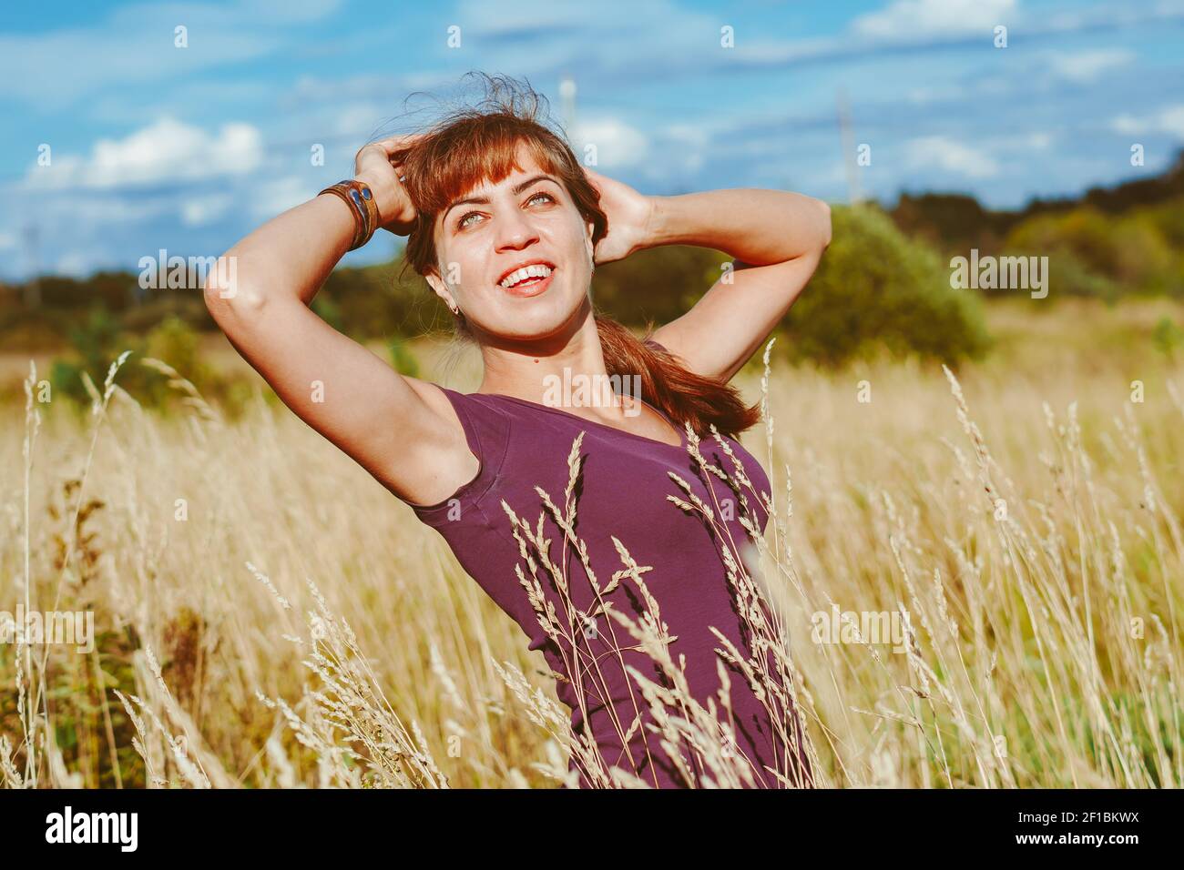 A girl in an evening dress on the field of lupins. A girl in a ...