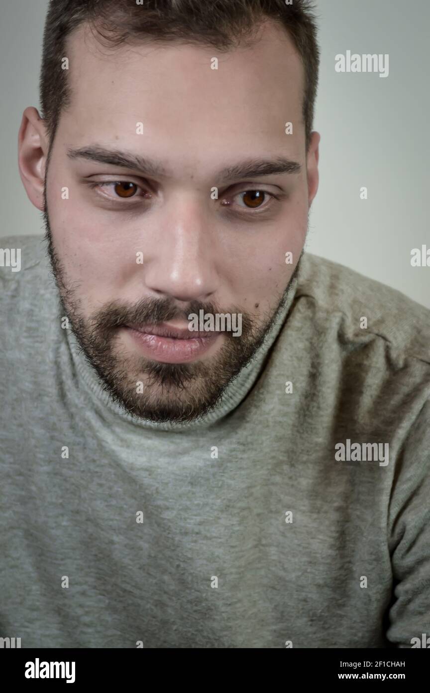 Portrait of a young brown-haired man with a short beard and a gray ...