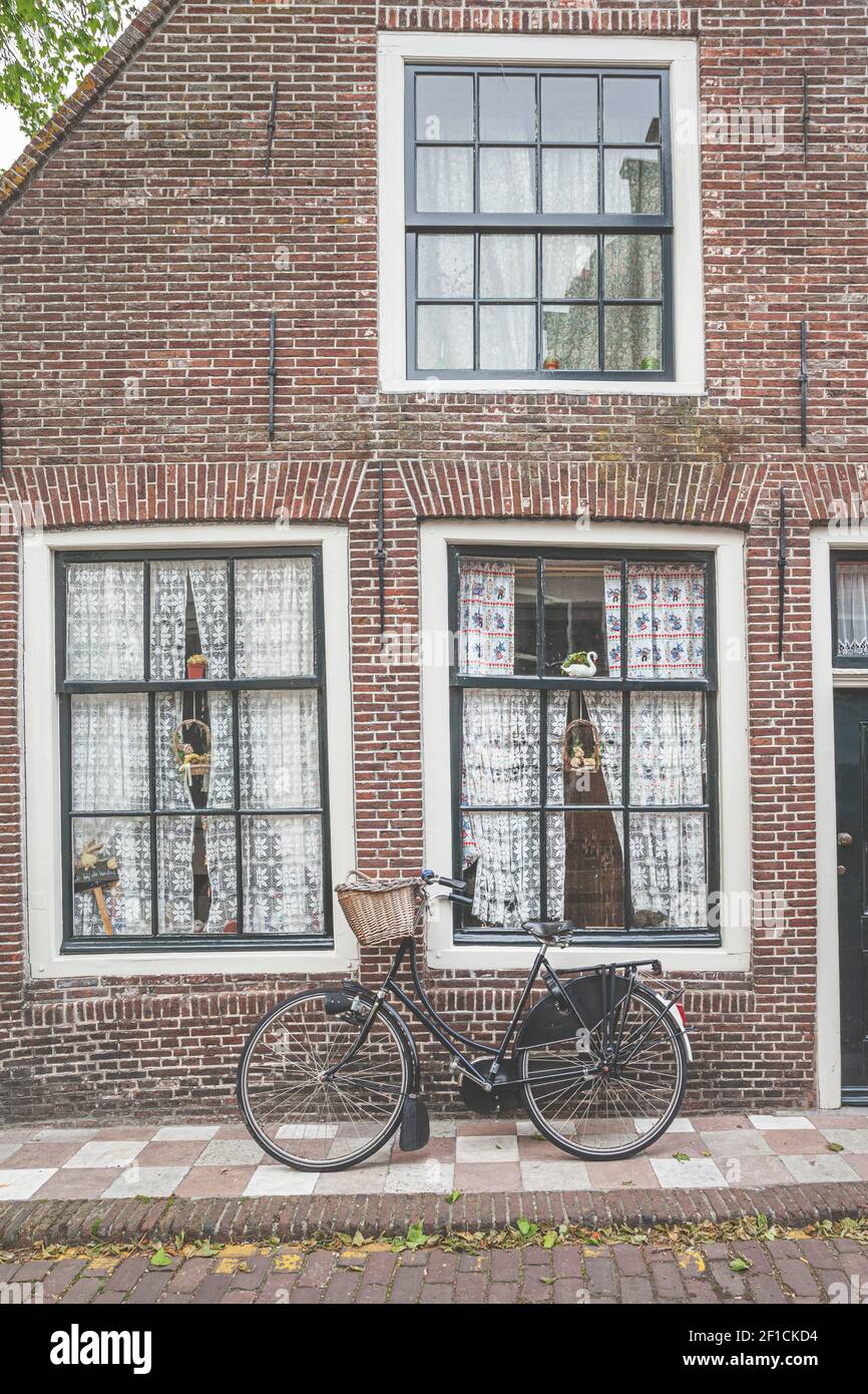 A traditional brick European (Dutch) home with a bicycle with a basket