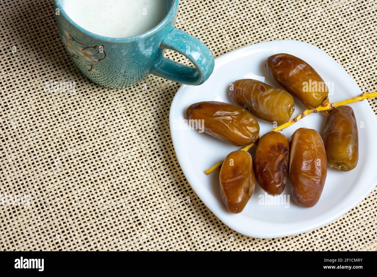 Top view of Algerian dates on a white plate with a mug of milk, Ramadan concept, space for text Stock Photo