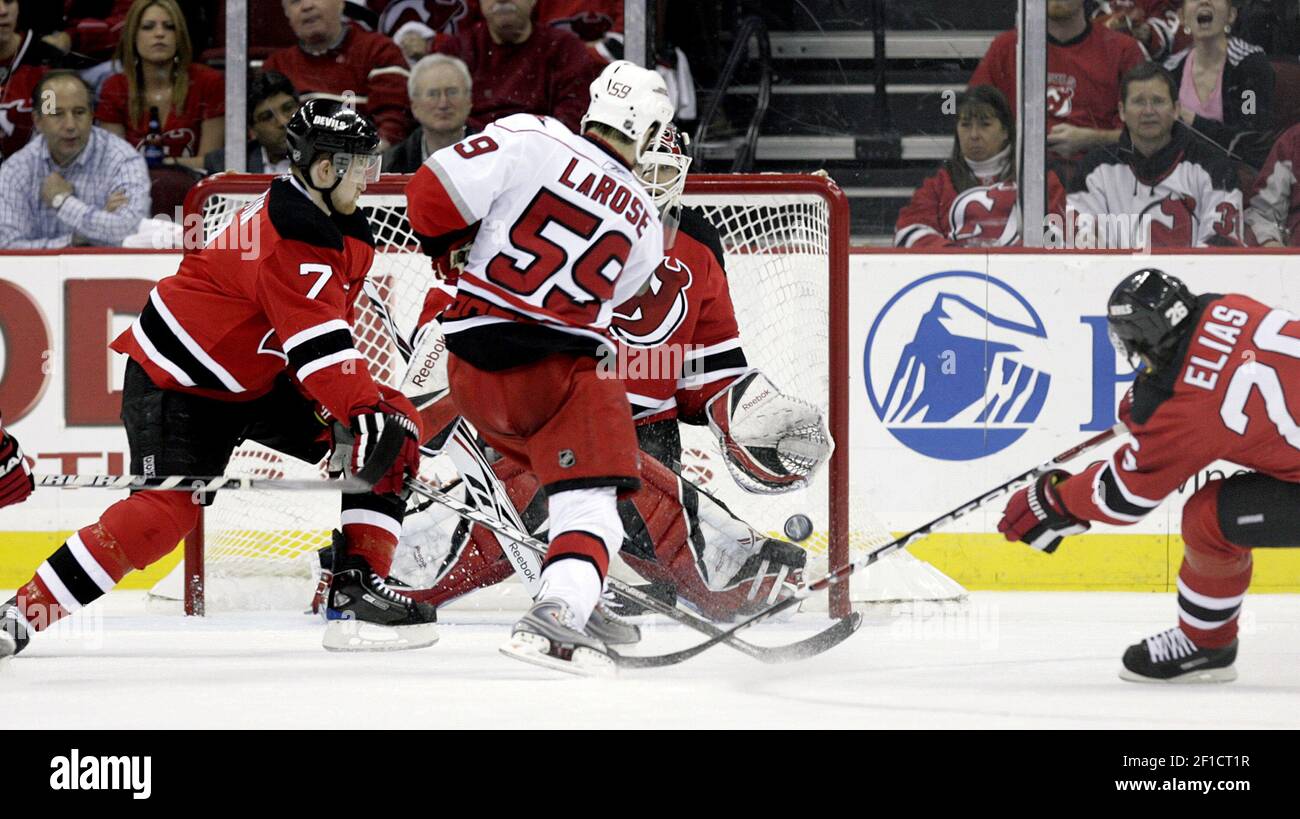 New Jersey Devils' Paul Martin, center, is checked by Atlanta