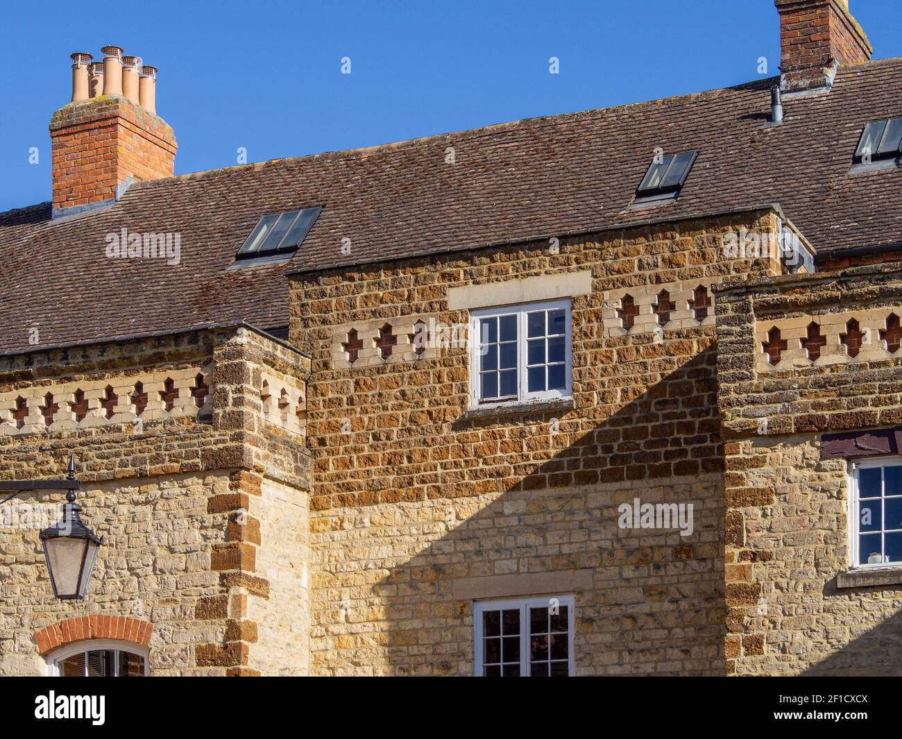 Close up of the roofline of a stone built building with a carved decorative stone frieze, Towcester, Northamptonshire, England, UK Stock Photo