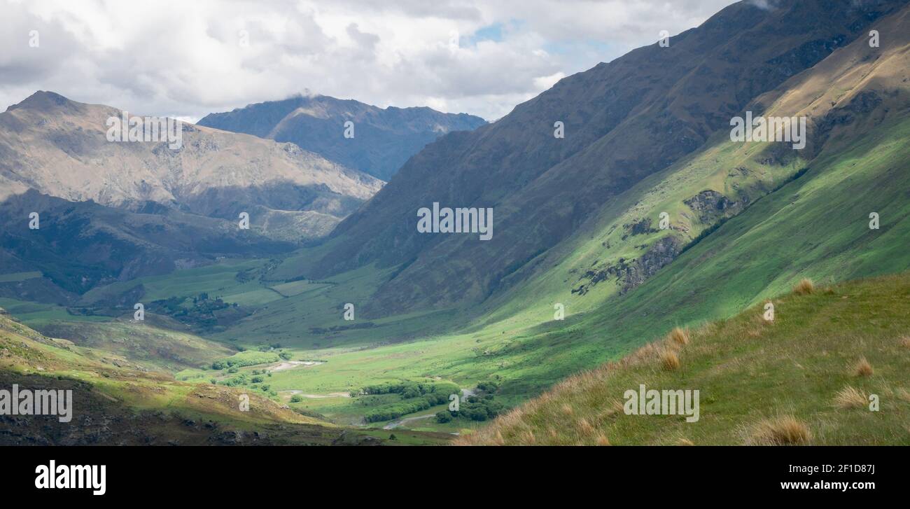 Lush green valley panoramic landscape shot made during overcast day in New Zealand Stock Photo