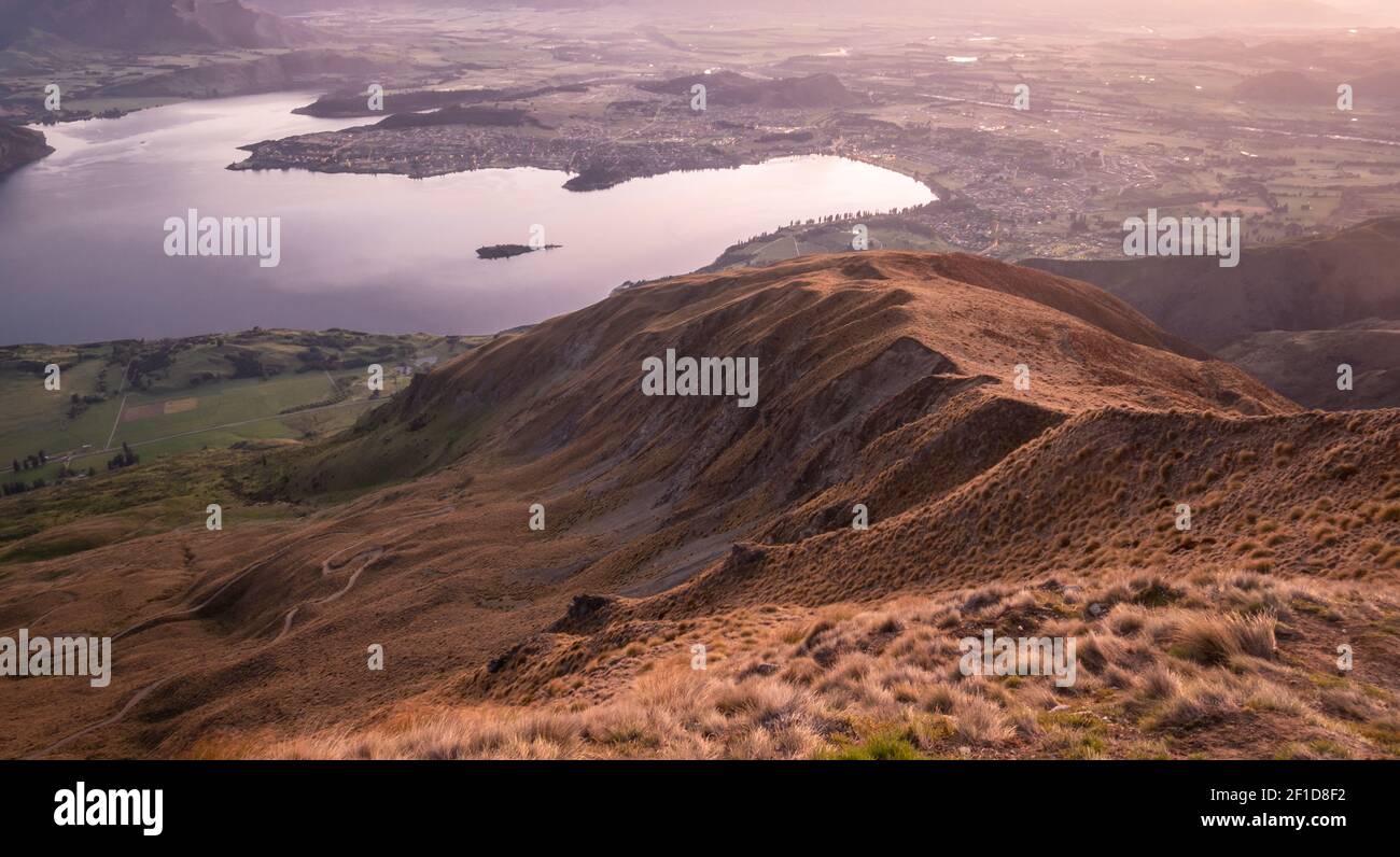 View on valley with lake during sunrise. Shot made on Roys Peak summit in Wanaka, New Zealand Stock Photo
