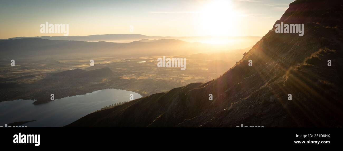 Sun rising over the valley with lake, shot made during sunrise on Roys Peak summit in Wanaka, New Zealand Stock Photo