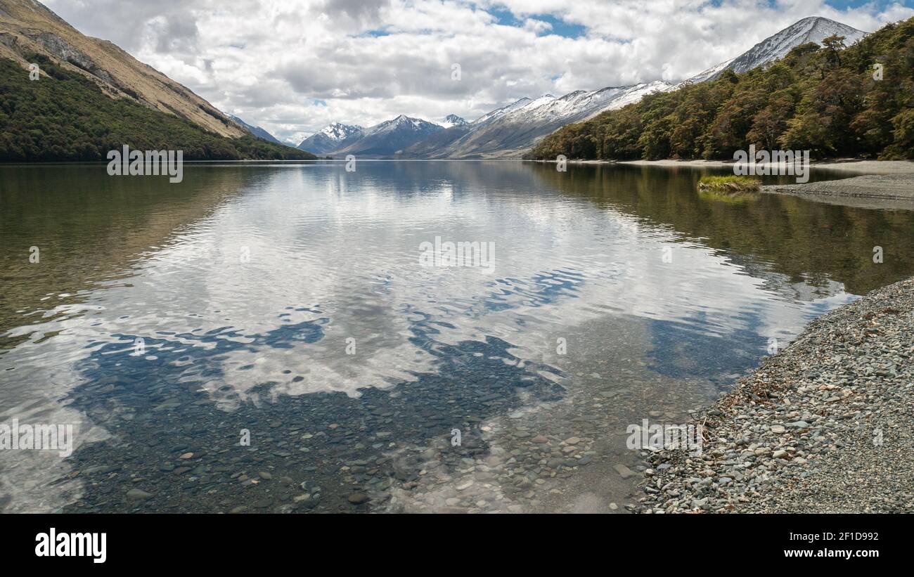 Crystal clear lake surrounded by forest and mountains, shot at Mavora Lakes, New Zealand Stock Photo
