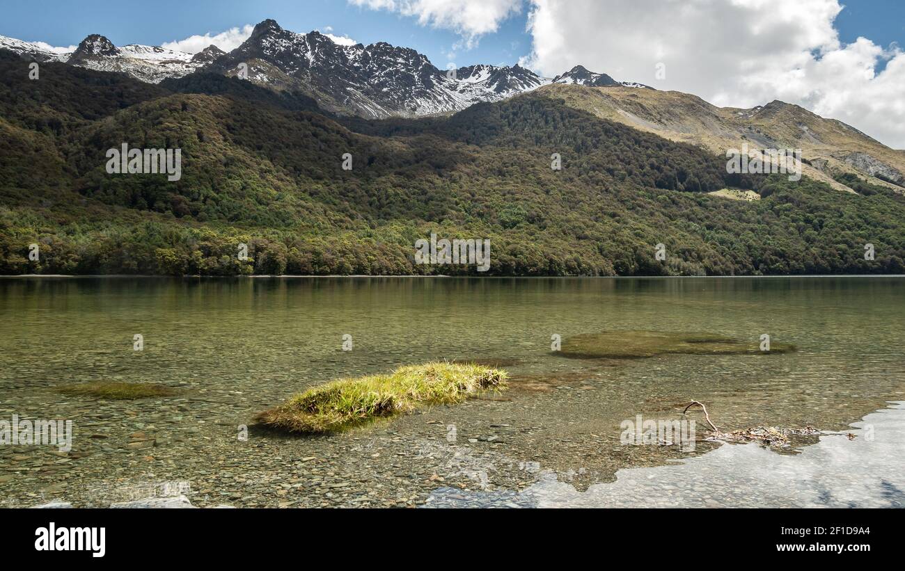 Crystal clear lake with forest and mountains in backdrop, shot at Mavora Lakes, New Zealand Stock Photo