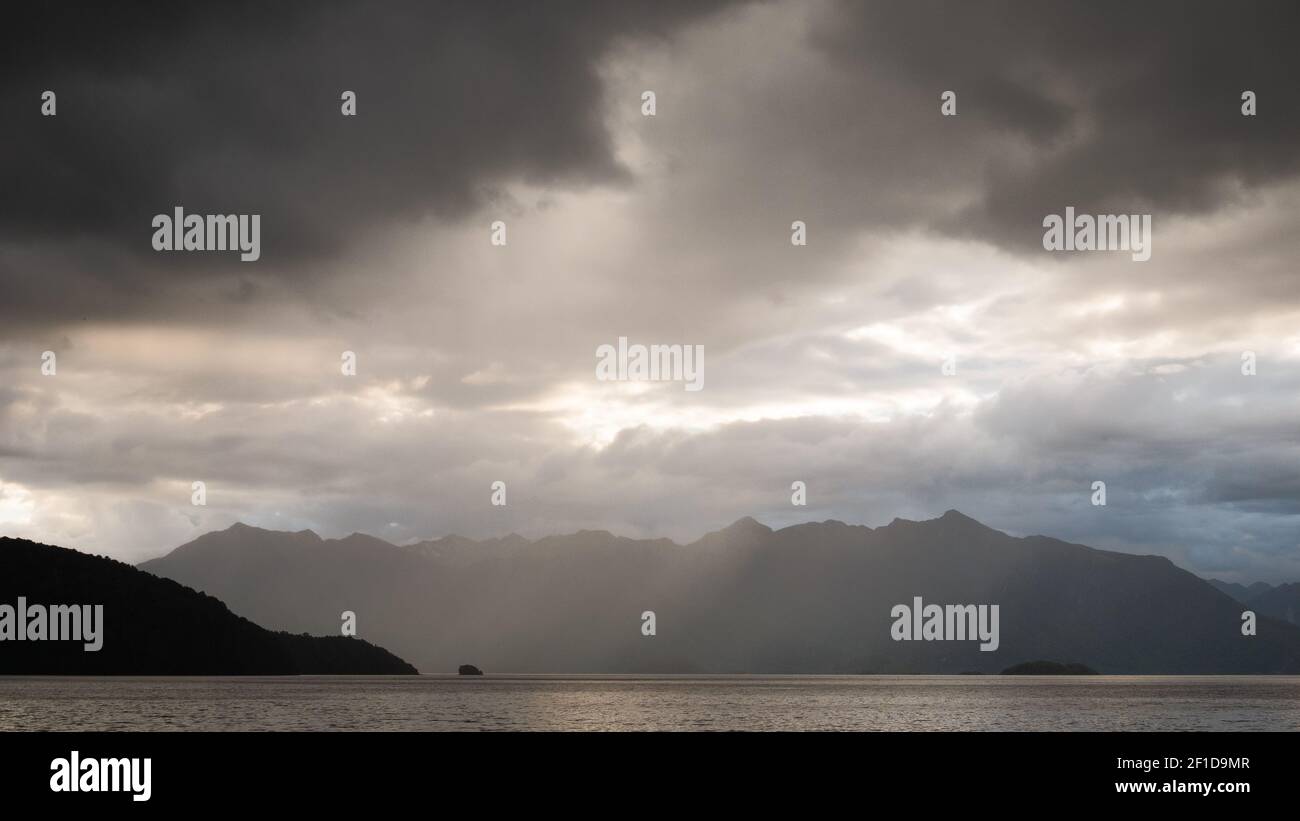 Storm clouds gathering over the lake and mountain range, shot at Kepler Track, Fiordland National Park, New Zealand Stock Photo