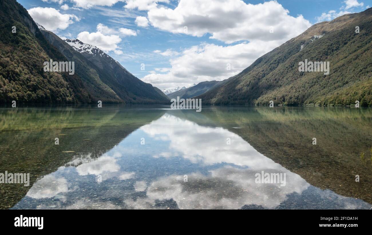Beautiful still reflections on a lake during sunny day. Symmetric photo taken at lake Gunn, Fiordland National Park, New Zealand Stock Photo