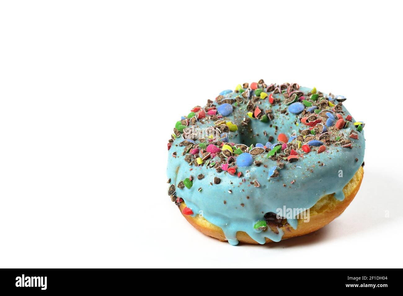 View of sweet donut with blue icing and crushed candies. Close Up of a round confectionery. Donut on a white background. Sweet dish. Ready to eat. Swe Stock Photo