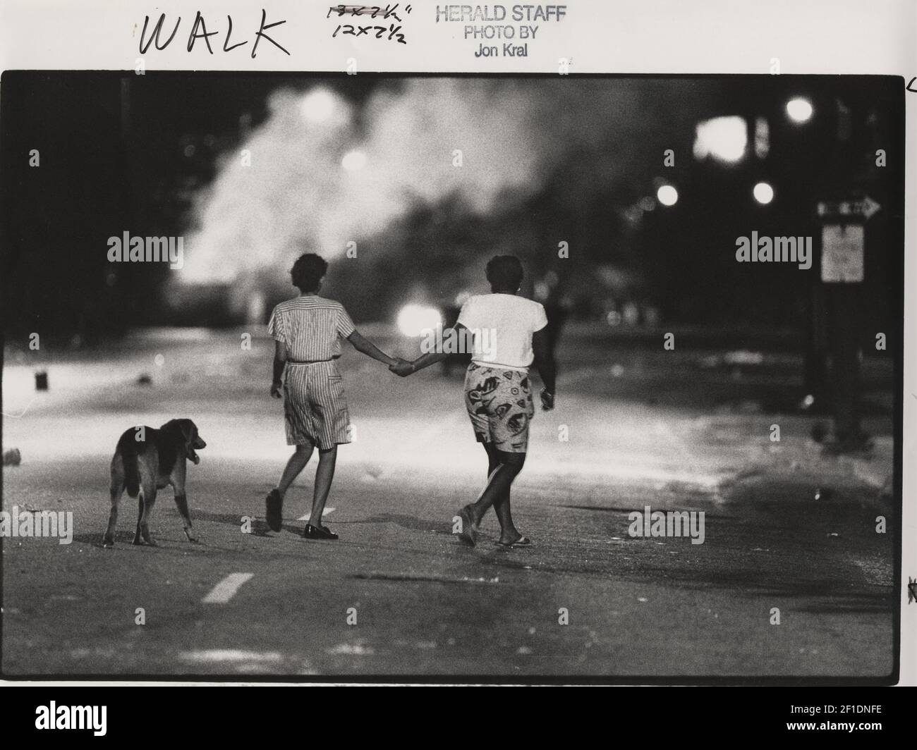 In the eerie glow of a burning warehouse, two women and a dog ...