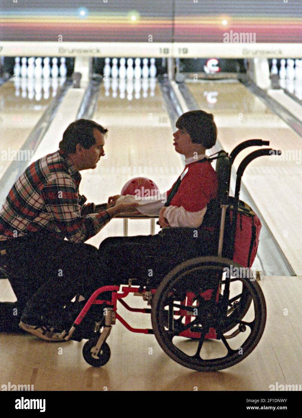 Jo Kelly school teacher Jim Radcliffe helps Marci Garvin, 20, during the Texas Special Olympics' sixth annual bowling tournament at Don Carter's All-Star Lane in Fort Worth, Texas, in November 1993. (Photo by Fort Worth Star-Telegram archive photo/TNS) *** Please Use Credit from Credit Field *** Stock Photo