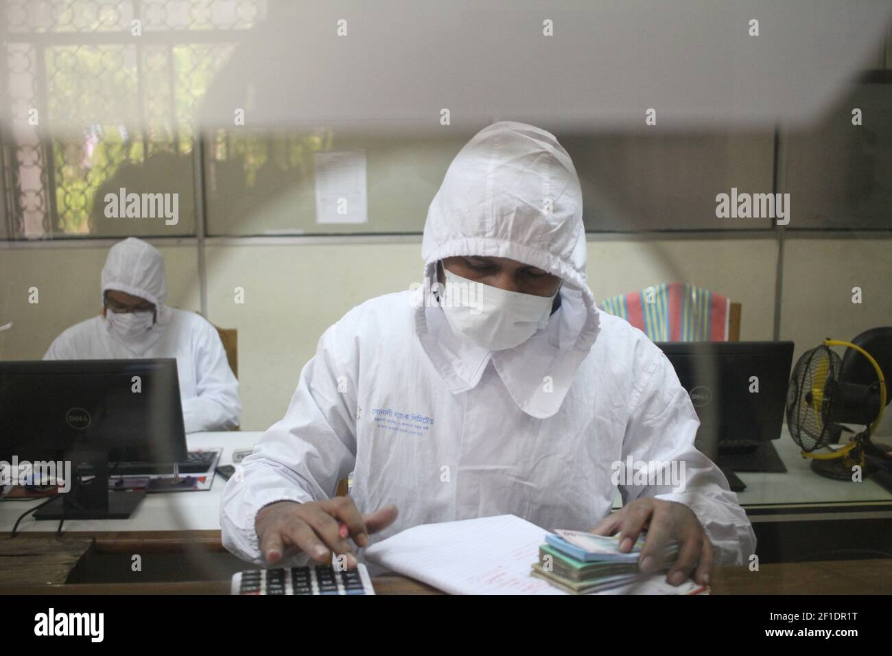 Bank employee wearing PPE (Personal protective equipment) amid fears of the spread the Coronavirus disease (COVID-19) in Dhaka, Bangladesh. Total 48 people have been infected by Covid-19 in Bangladesh, of whom 5 died said IEDCR official. (Photo by Md Abu Sufian Jewel/Pacific Press/Sipa USA) Stock Photo