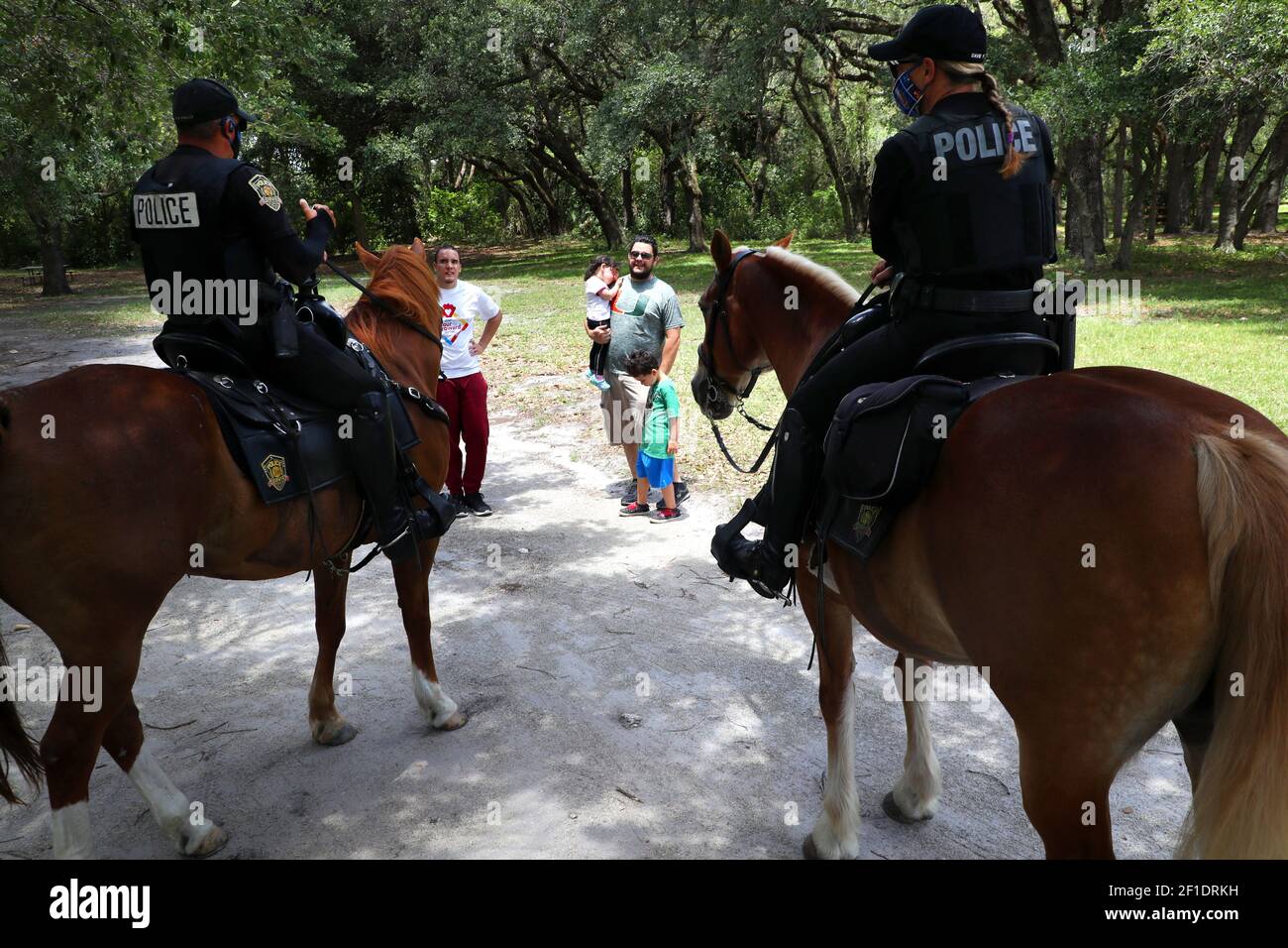 Davie mounted police officers greet a family while enforcing social distancing at Tree Top Park in Davie. Palm Beach Broward and Miami Dade counties reopened county parks with some limitations aiming to keep people apart on April 29,2020. (Photo by Carline Jean/South Florida Sun Sentinel/TNS/Sipa USA) Stock Photo