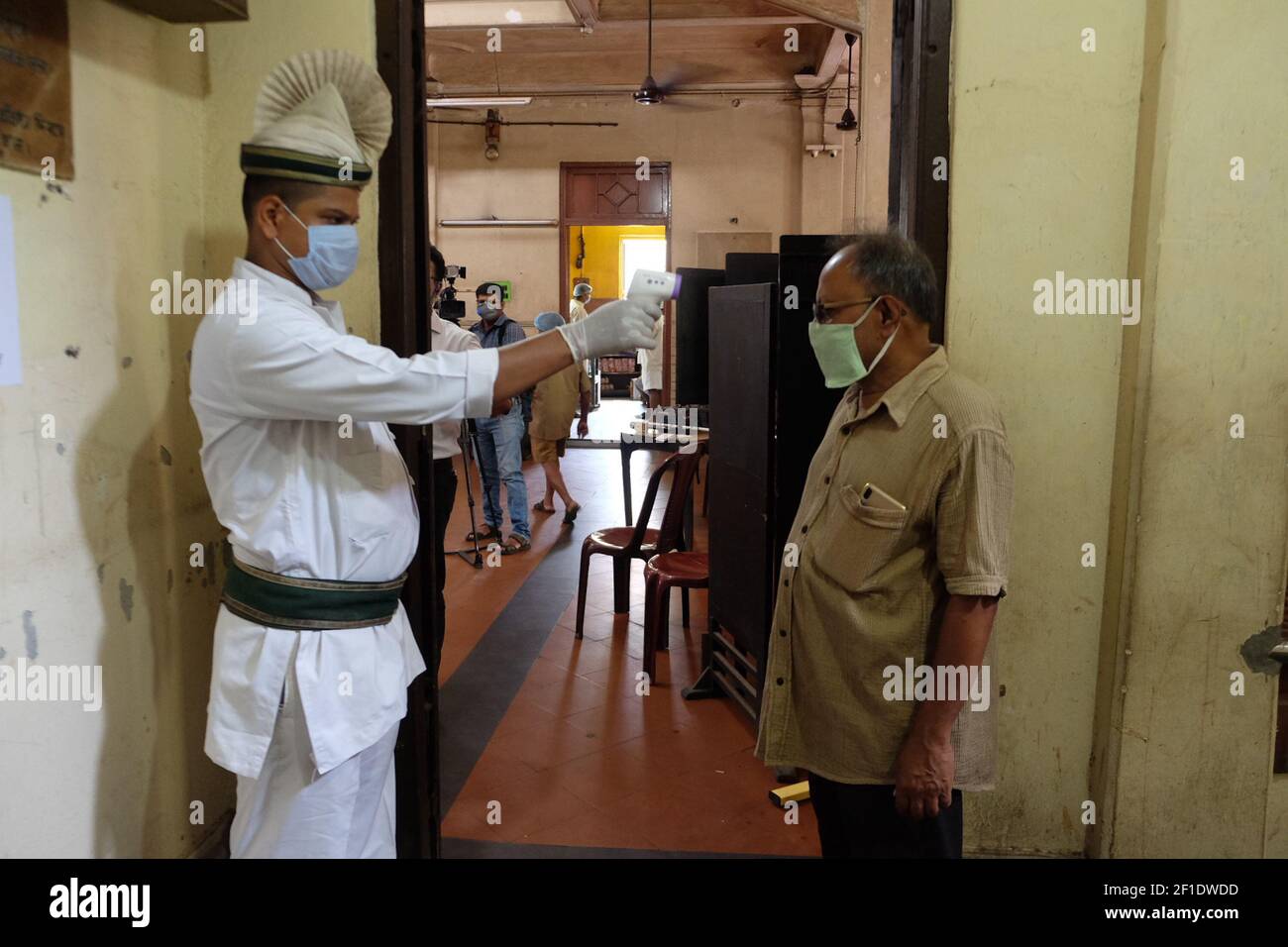 A staff is checking the temperature before a customer enters inside the coffee house.The iconic Indian Coffee House is set to open with several crucial norms of COVID-19 from today,Thursday, July 2, 2020. After a gap off over three months due to Coronavirus Pandemic. (Photo by Satyajit Shaw/Pacific Press/Sipa USA) Stock Photo