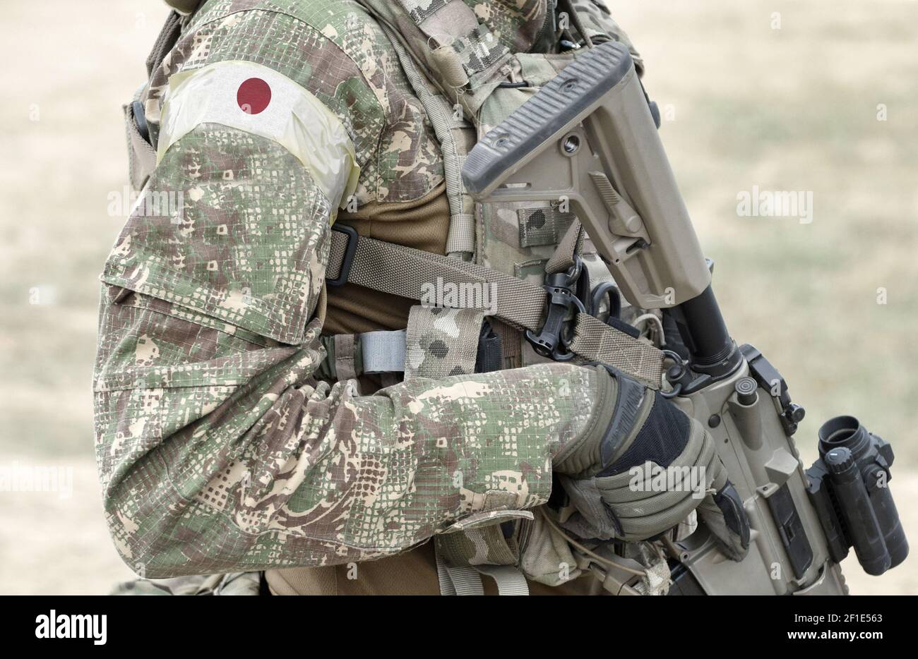 Soldier with assault rifle and flag of Japan on military uniform. Collage. Stock Photo