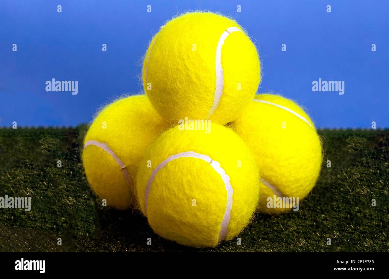 Four yellow tennis balls in studio setting, London, England, United Kingdom Stock Photo