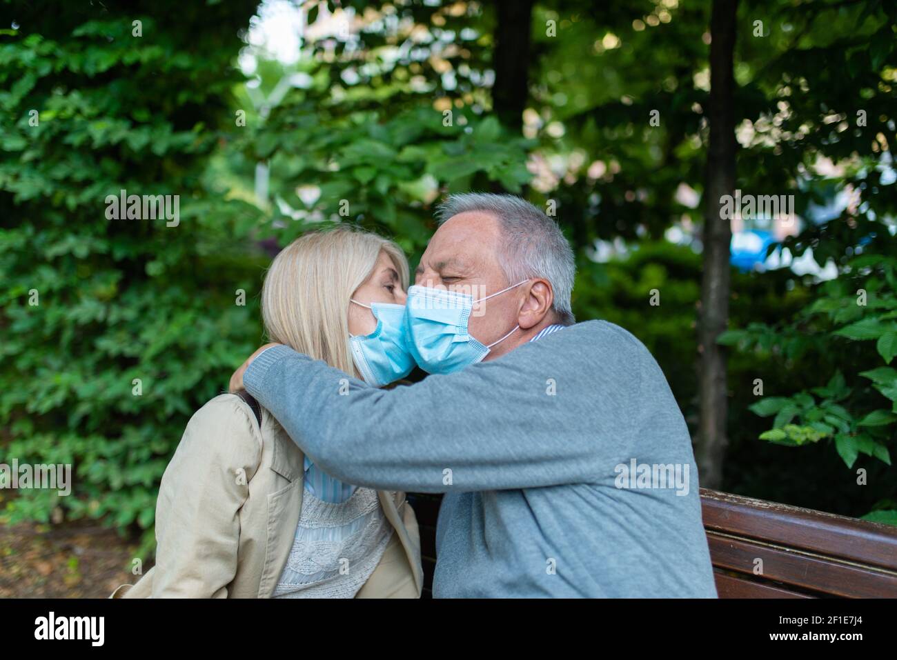 Romantic mature couple in a park during Coronavirus pandemic, love and hope concept Stock Photo