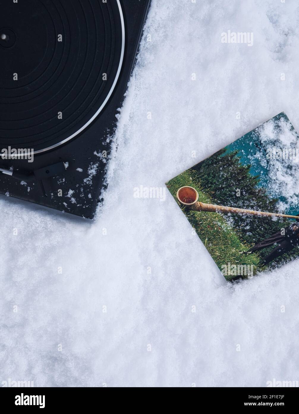 Directly above of turntable and 45 rpm vinyl record cover in snow. Concept of retro, nostalgia, yesteryear, Stock Photo