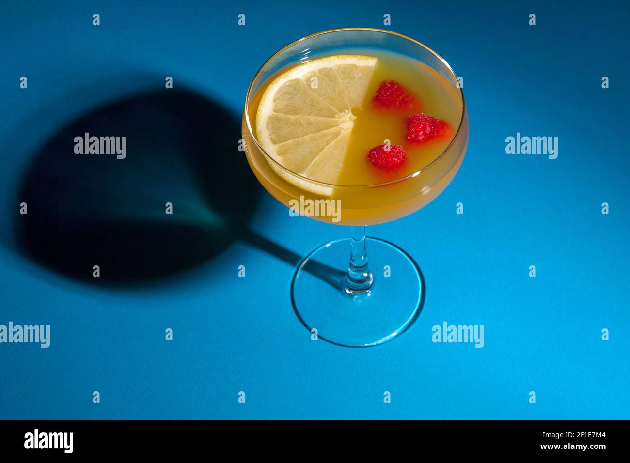 Grapefruit and raspberry cocktail on blue backdrop Stock Photo - Alamy