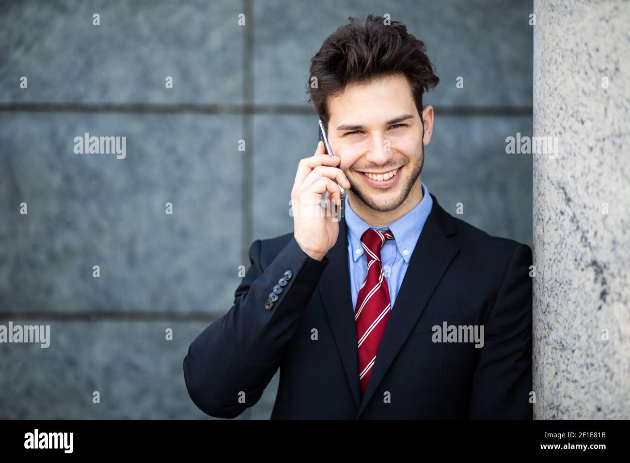 Young manager on the phone outdoor in an urban setting Stock Photo - Alamy