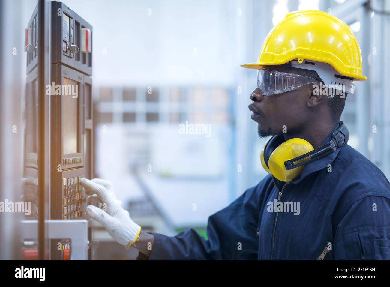 Black man working at programmable machine in factory industries Stock Photo