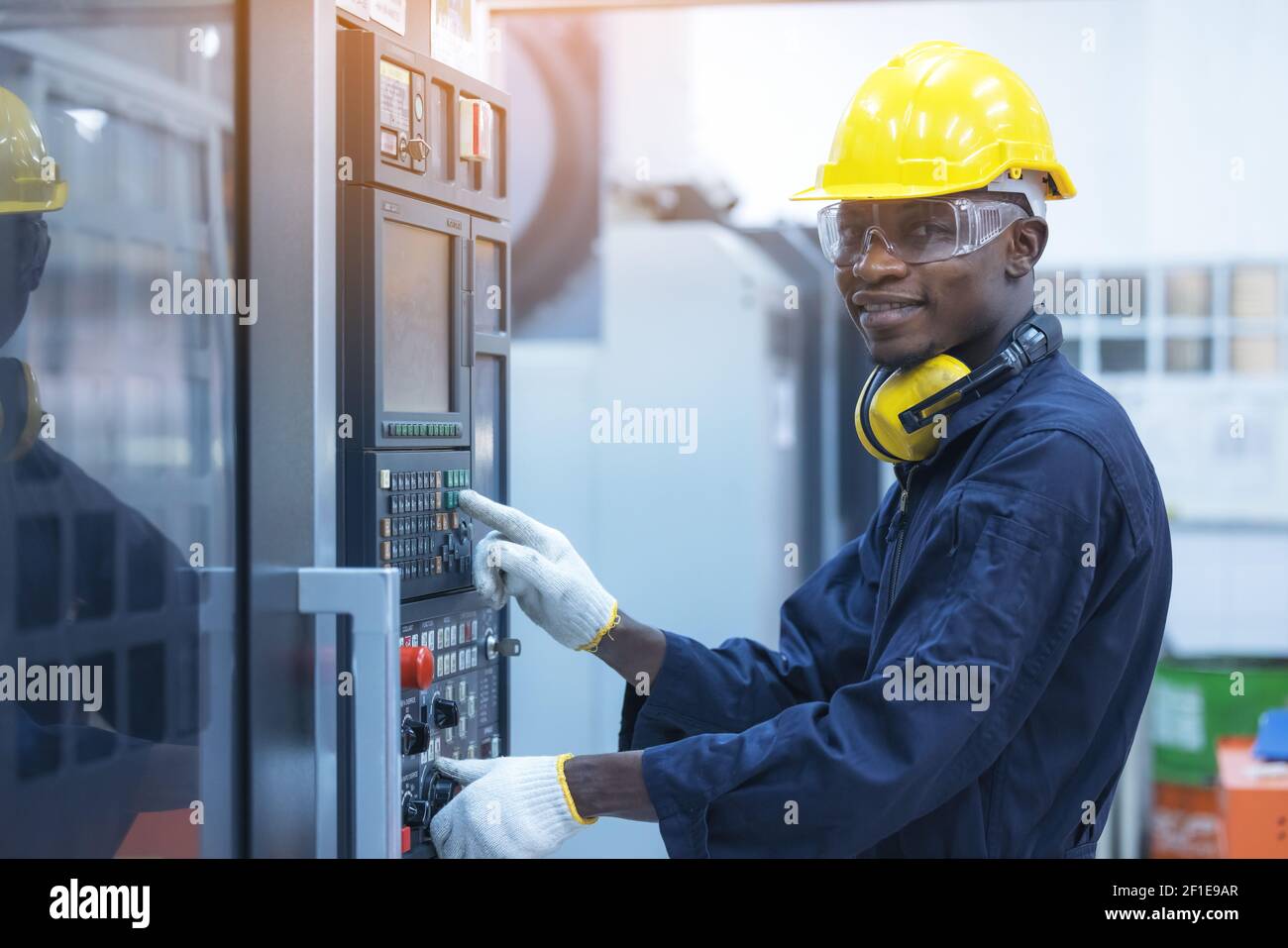 Black man working at programmable machine in factory industries Stock Photo