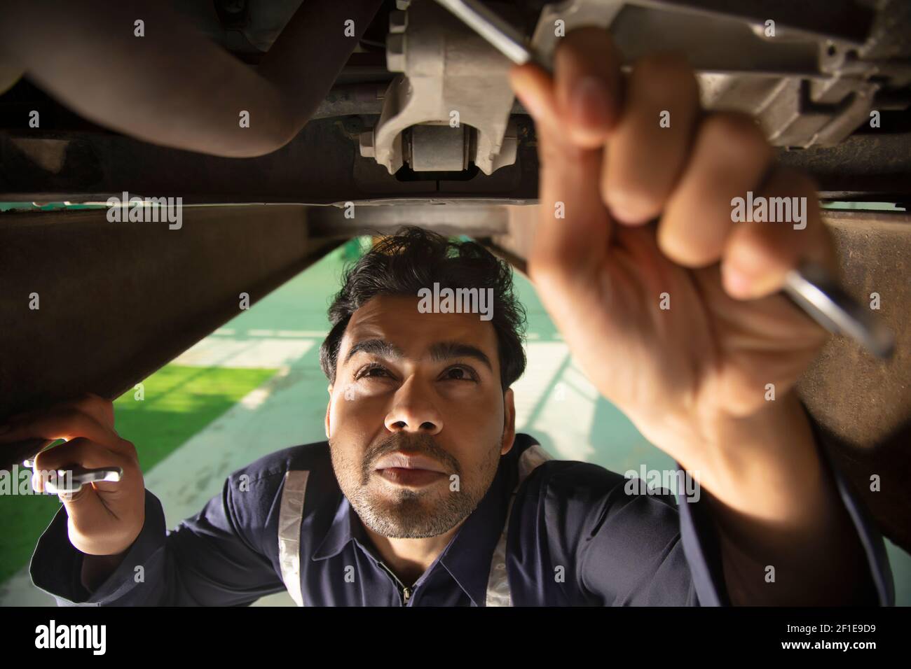 Car mechanic working under a vehicle at Stock Photo Alamy