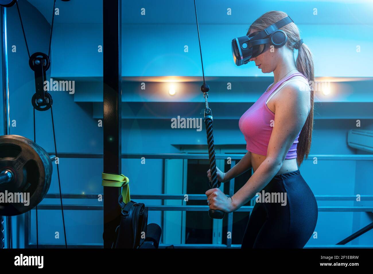 Attractive young red hair sportswoman training triceprs in the gym of her beautiful house with vr futuristic goggles - Ginger athletic model Stock Photo