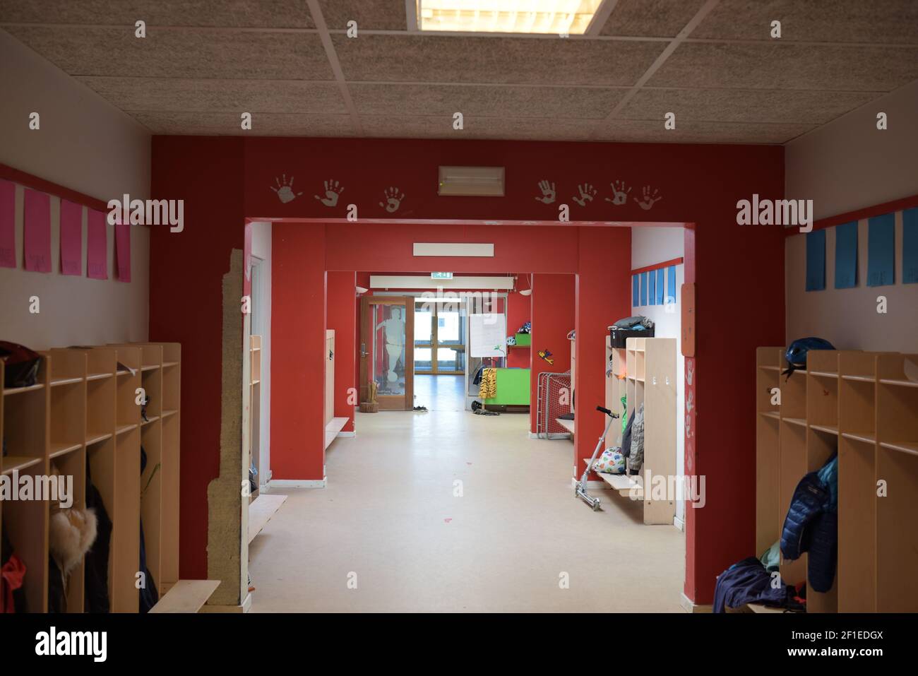 A red empty school hallway with kids hand-prints on the walls Stock Photo