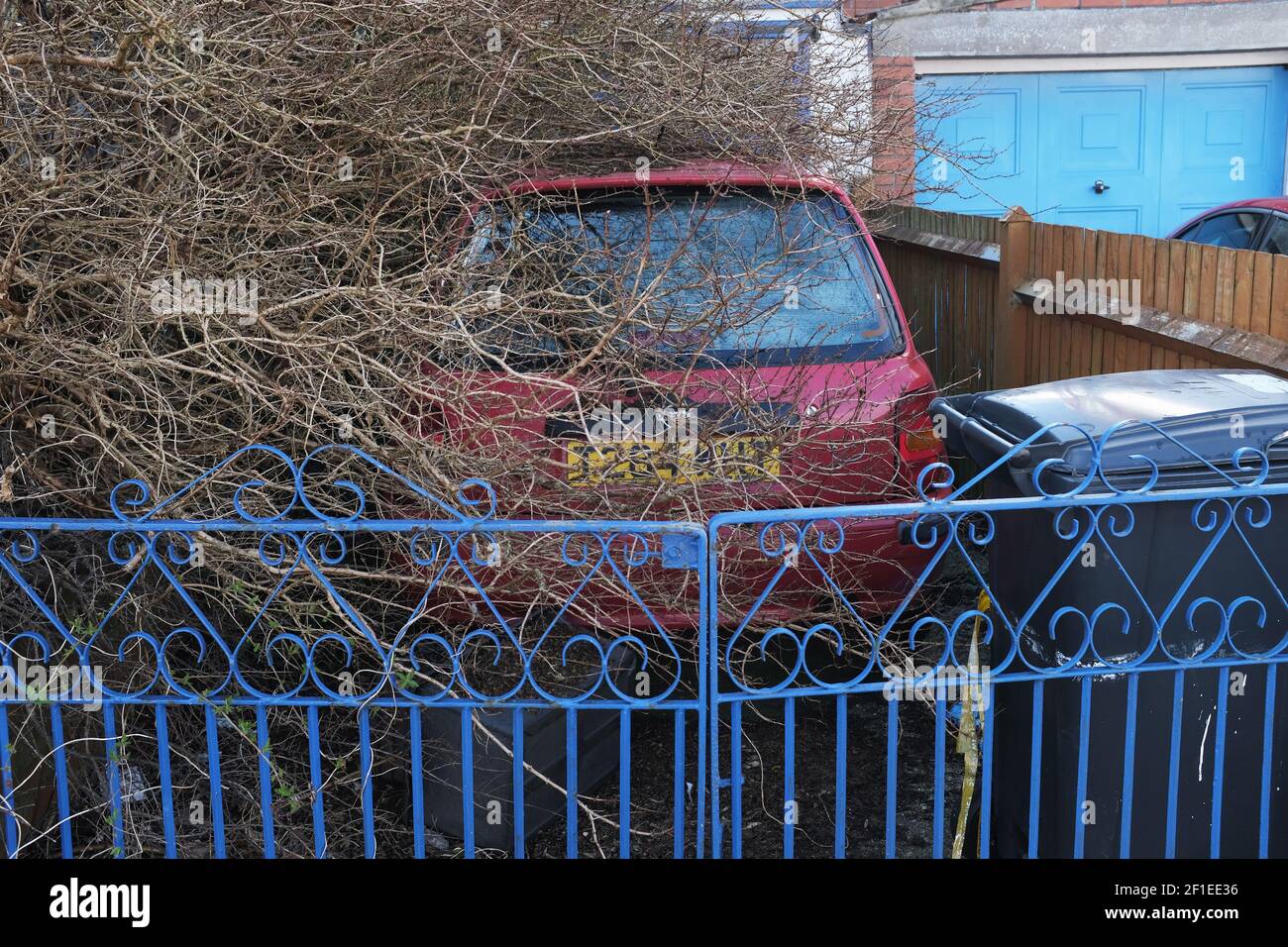 An abandoned car in a front garden. Stock Photo
