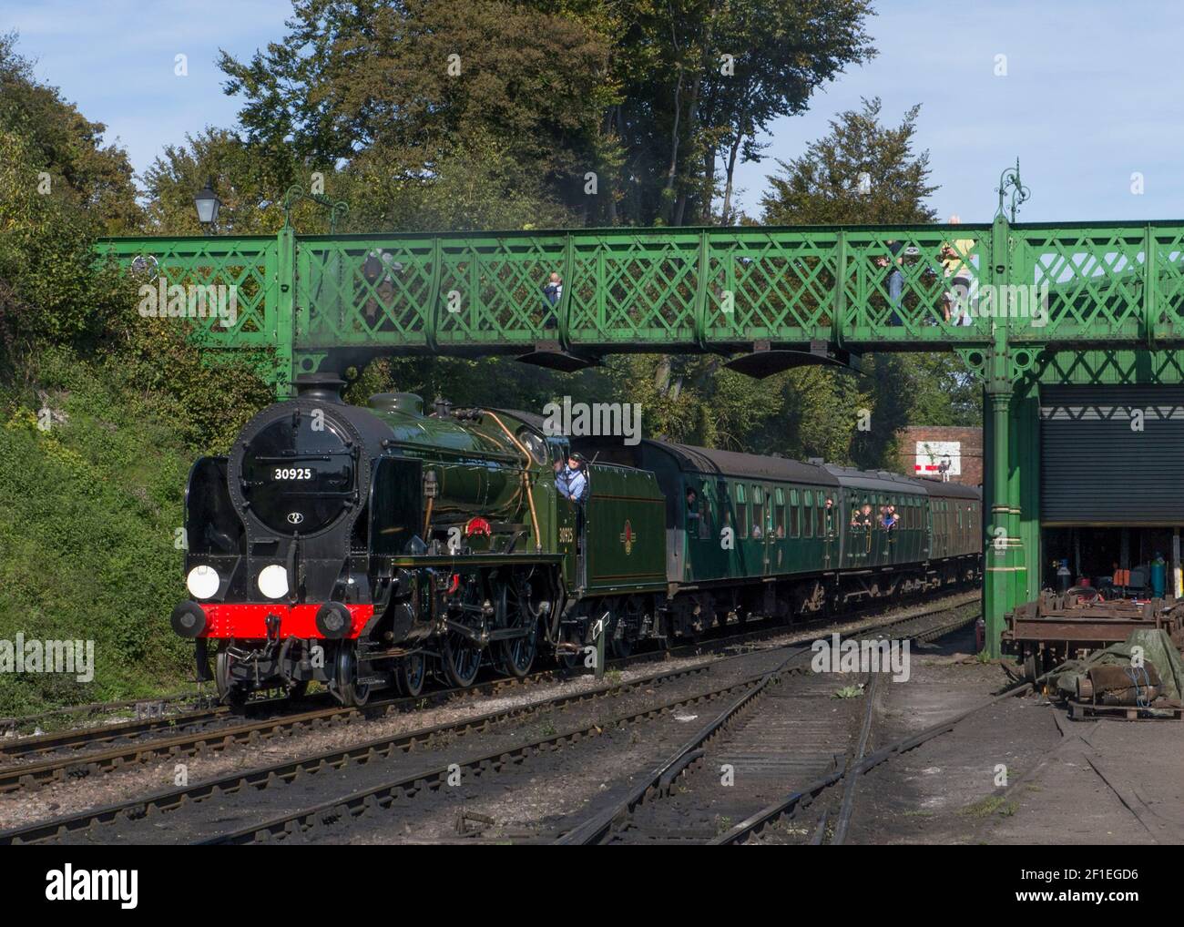 A steam train passes under the Harry Potter bridge at Ropley staion on