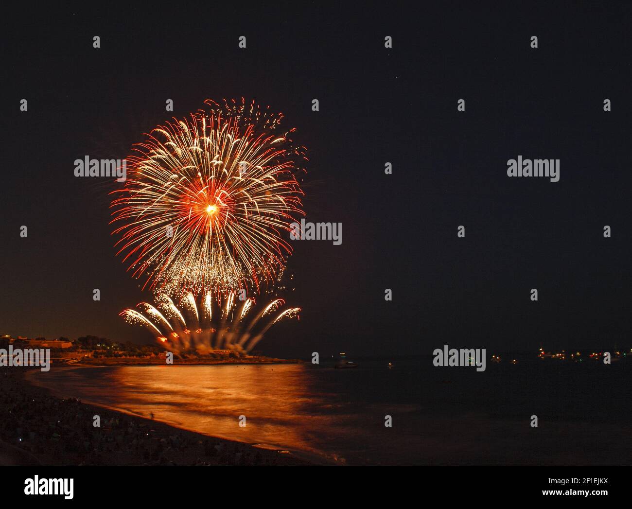 Fireworks display over sea with reflections Stock Photo