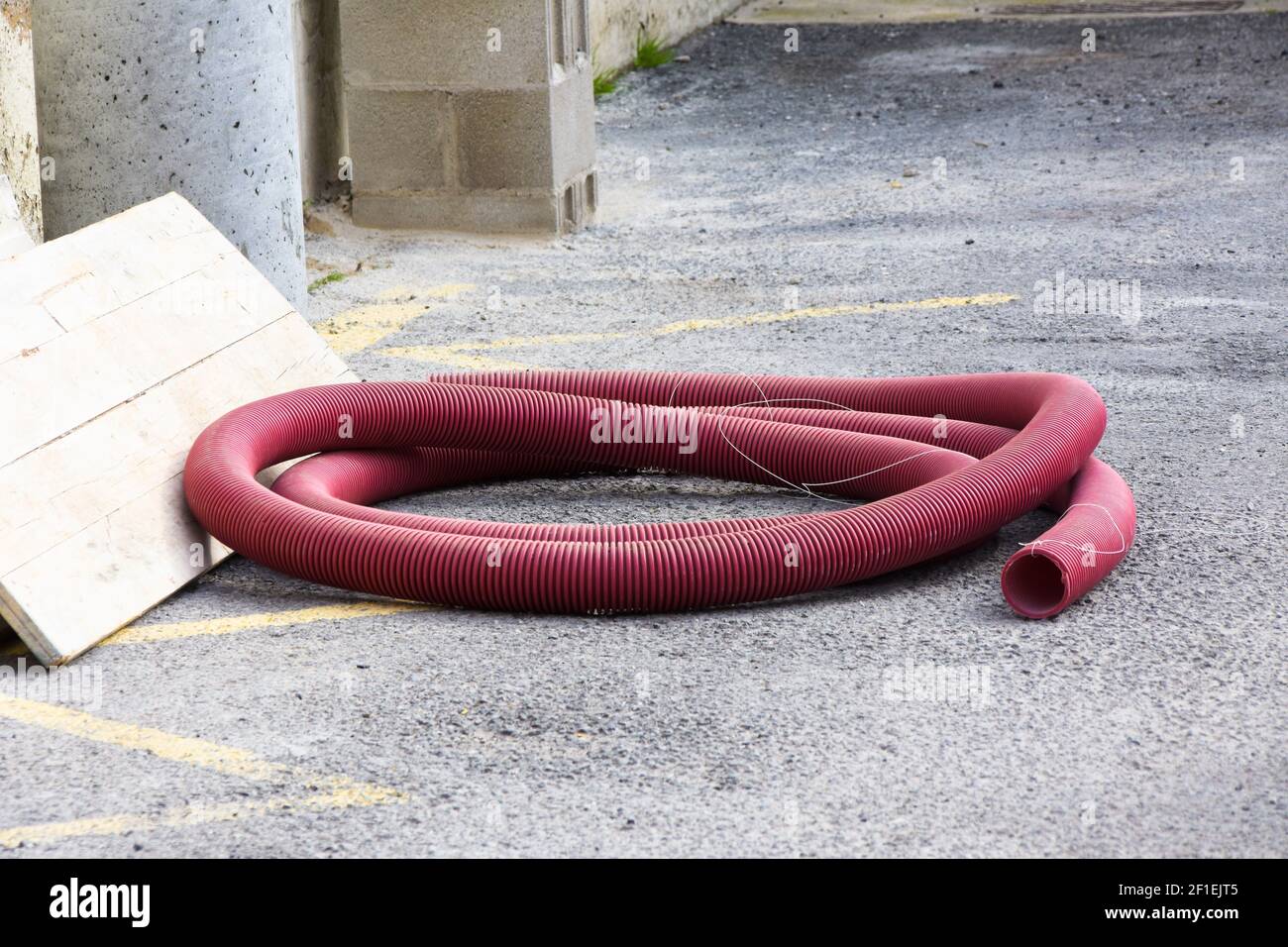 Red plastic tubing for underground cable protection, pvc pipe. Stock Photo