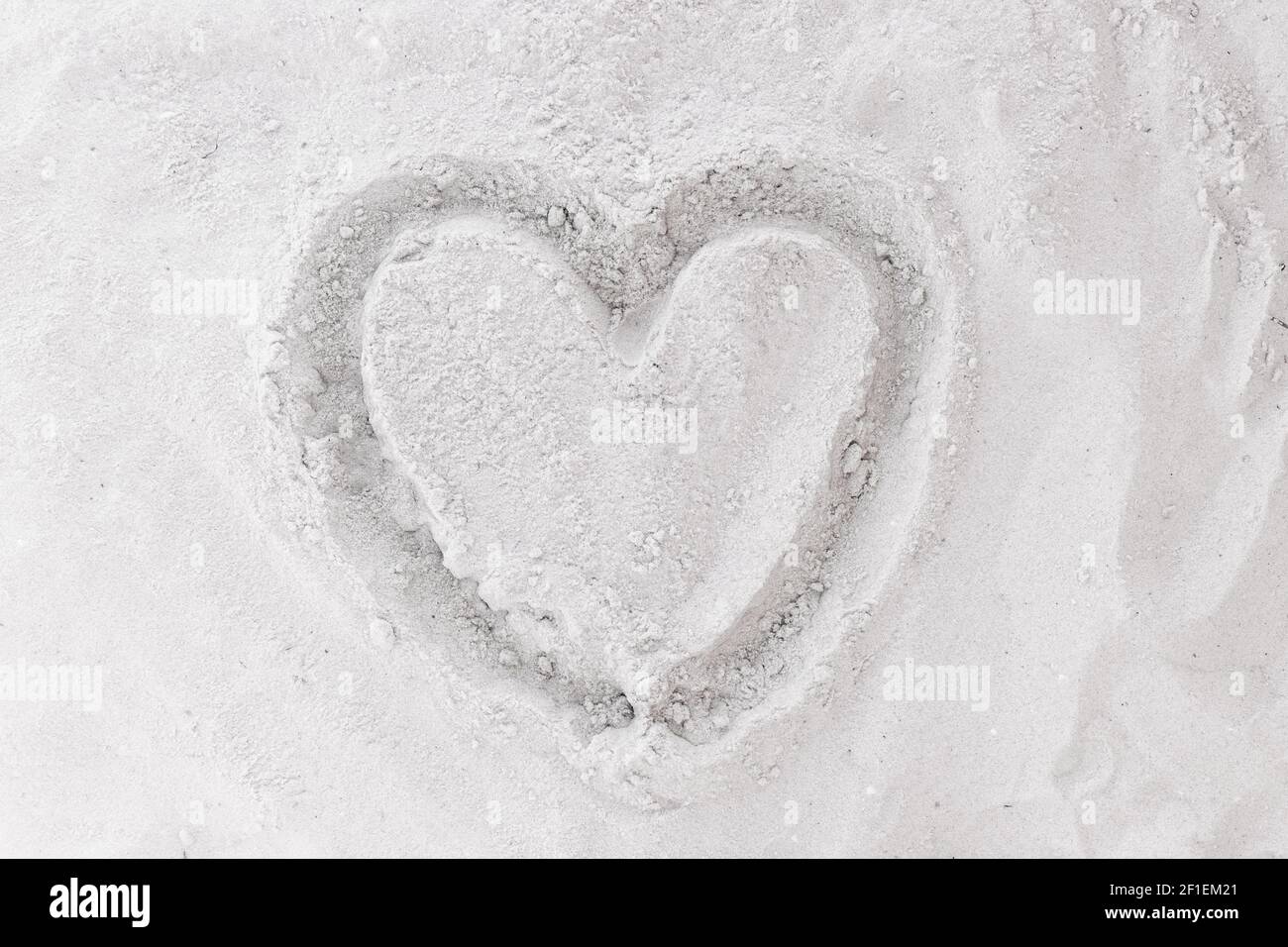 Sign or symbol of love drawing hearts on white beach sand background. Stock Photo