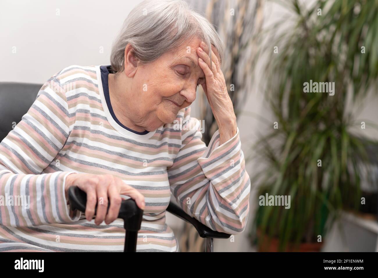 Elderly woman sitting and having headache Stock Photo Alamy