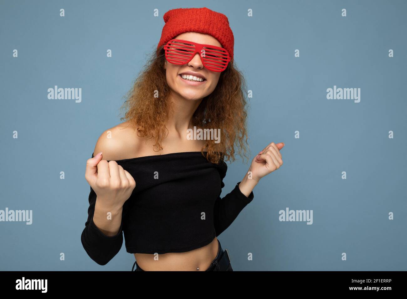 Photo shot of beautiful positive young dark blonde woman wearing casual clothes red bandana and stylish sunglasses isolated over colorful background Stock Photo