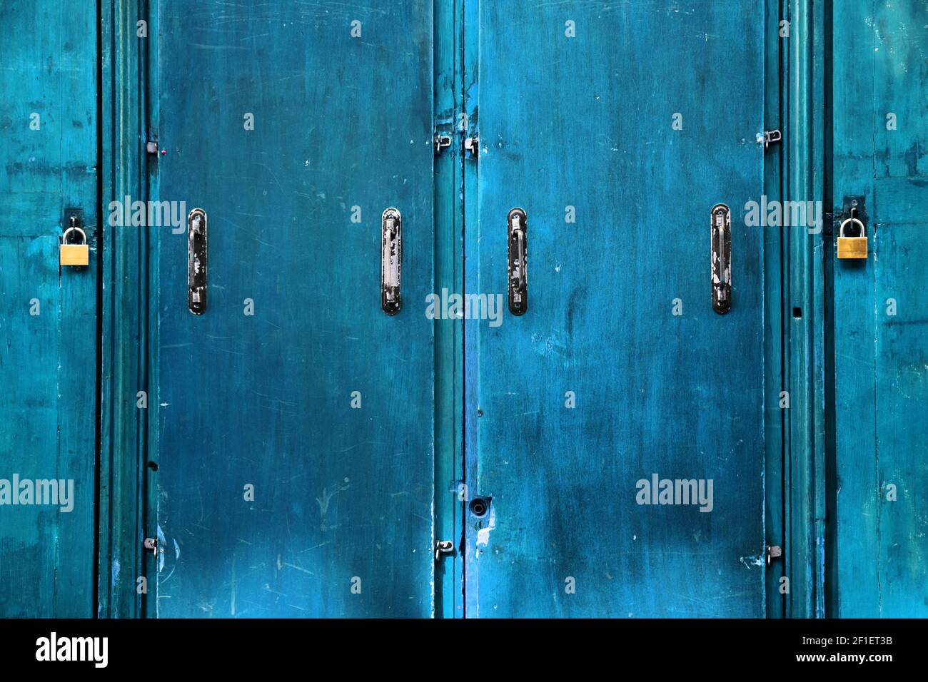 Double security. Old blue doors closed with padlocks. Safety concept. Abstract vintage background. Stock Photo