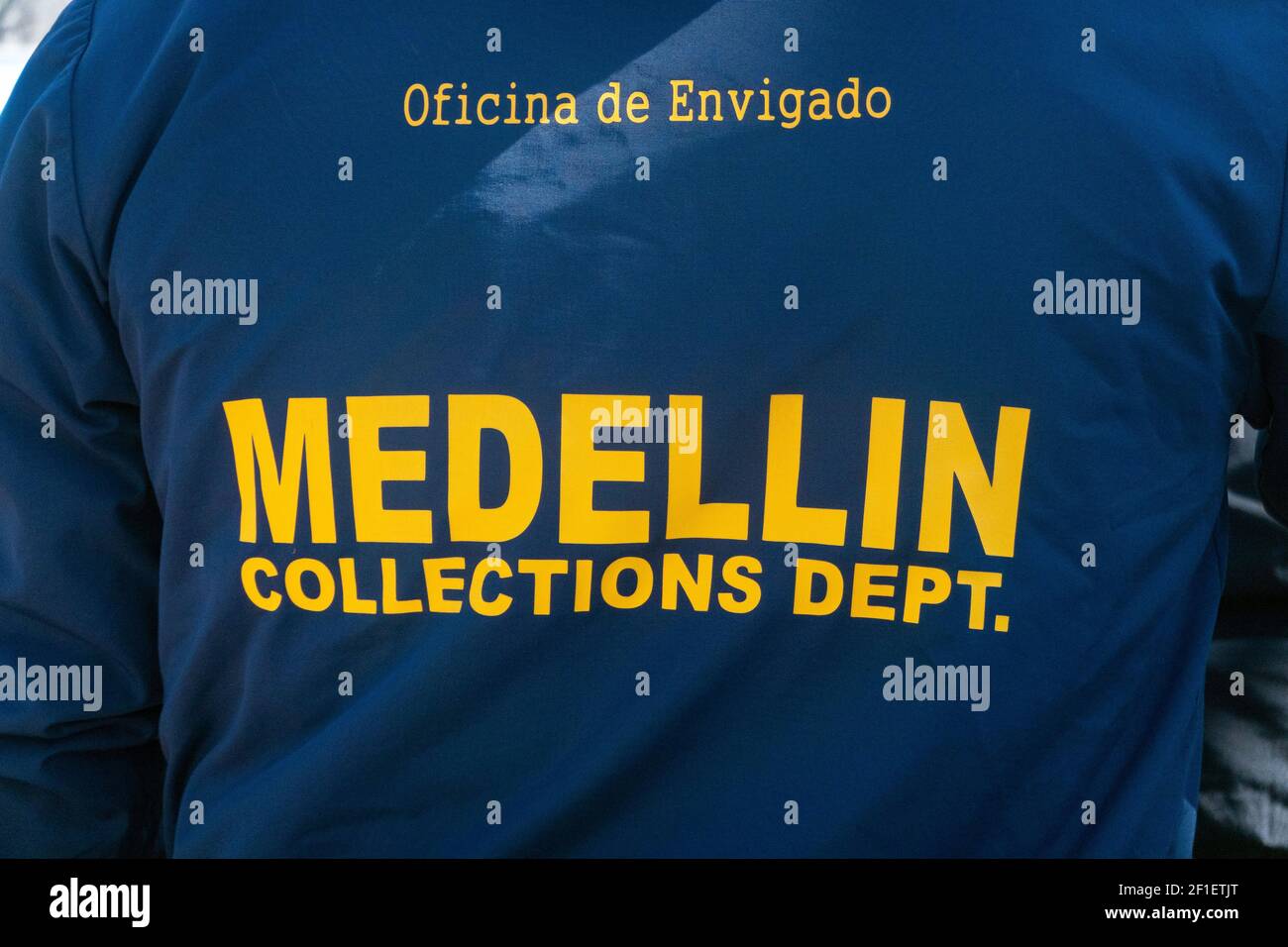 An unidentified man wearing a sweatshirt saying that he's from the Medellin Collections Department. In  New York City. Stock Photo