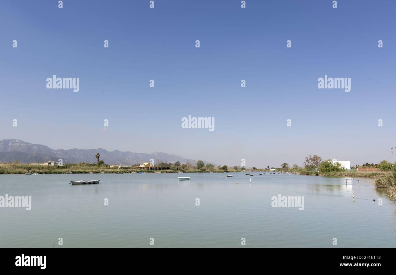 Calm lake with fishing boats. Fresh water lagoon in Estany de cullera. Valencia, Spain Stock Photo