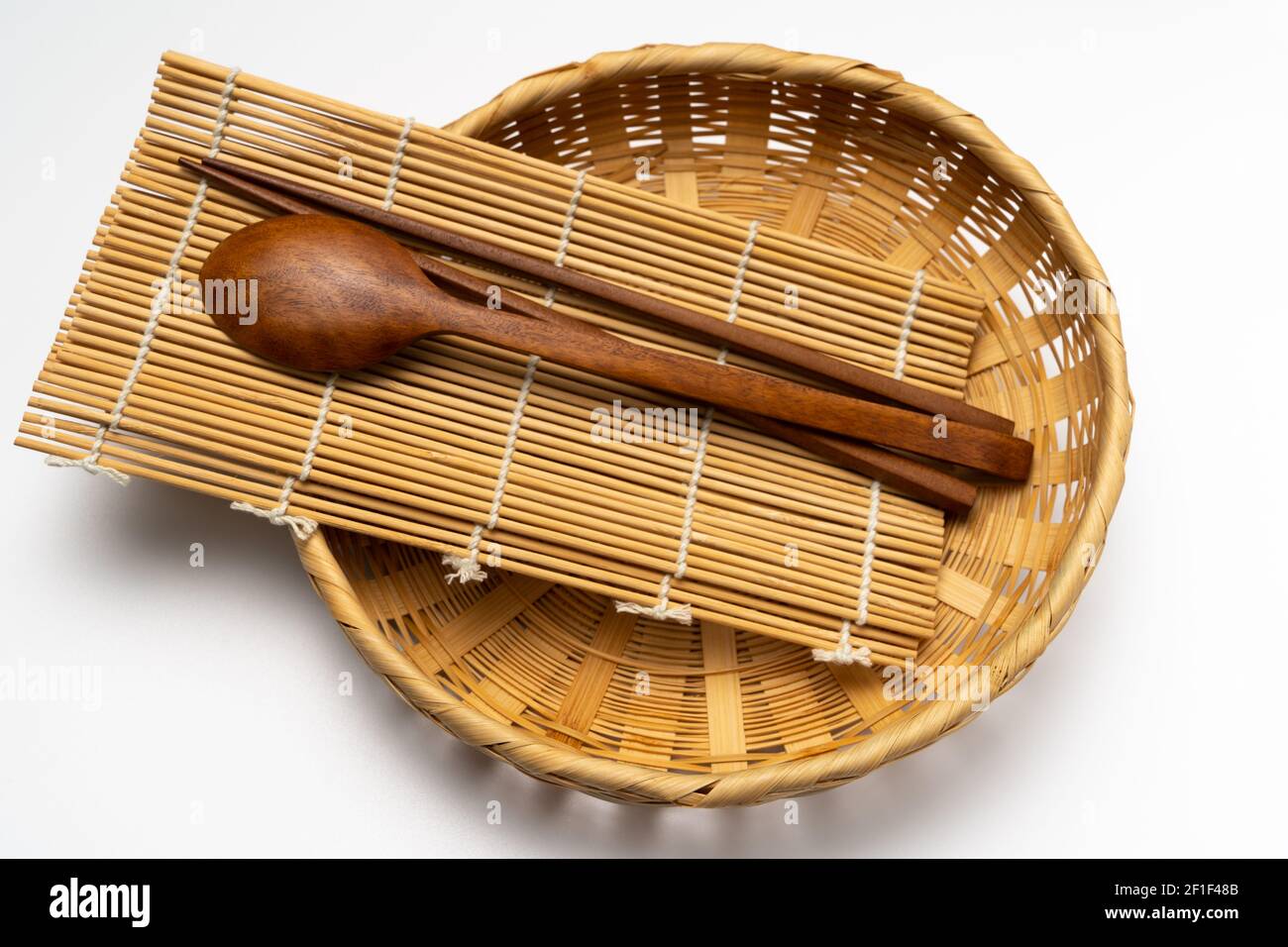 Wooden cutlery, wooden chopsticks, bamboo basket, bamboo mat Stock Photo