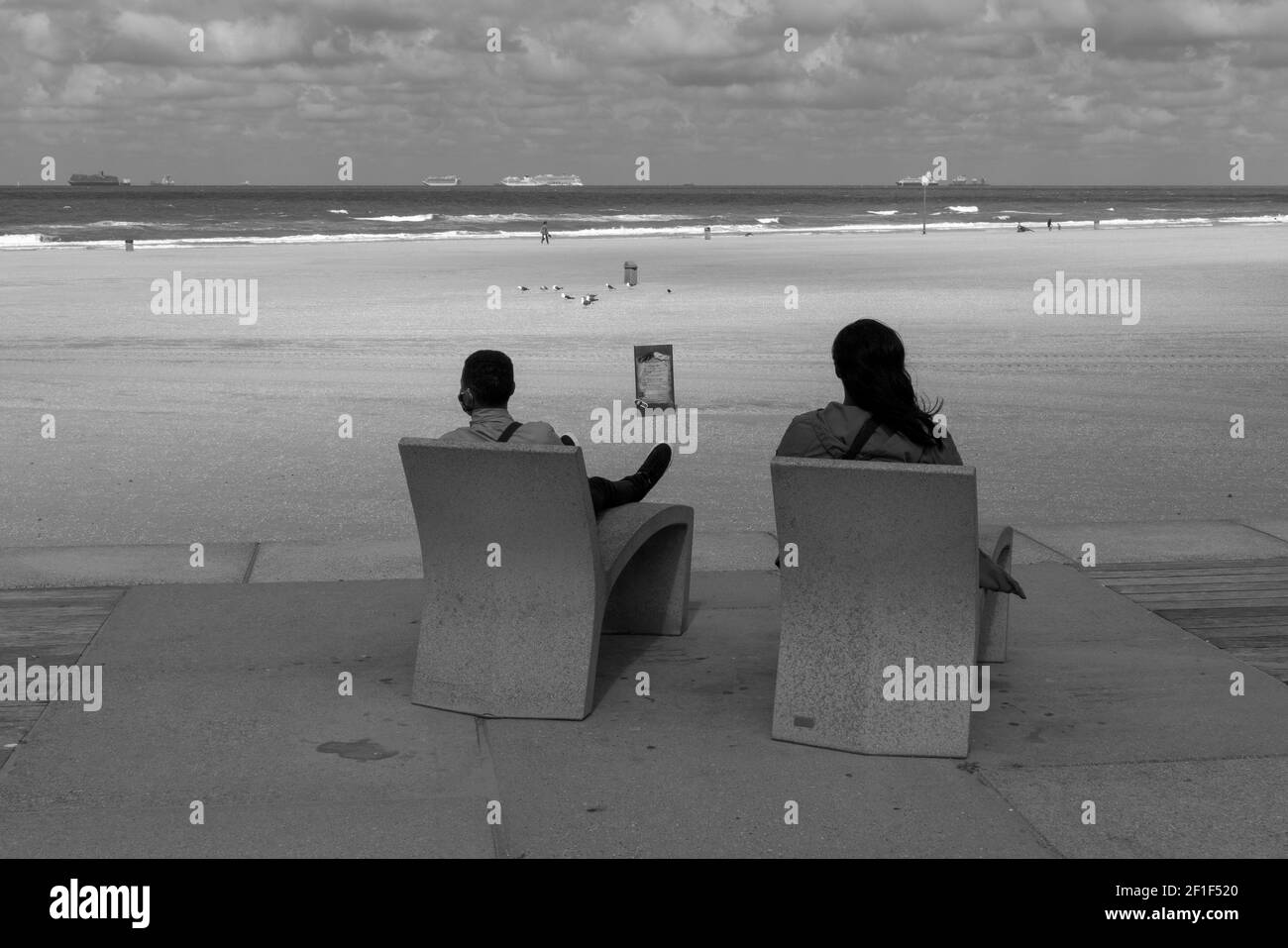 Two people rest in front of the beach in Scheveningen. Stock Photo