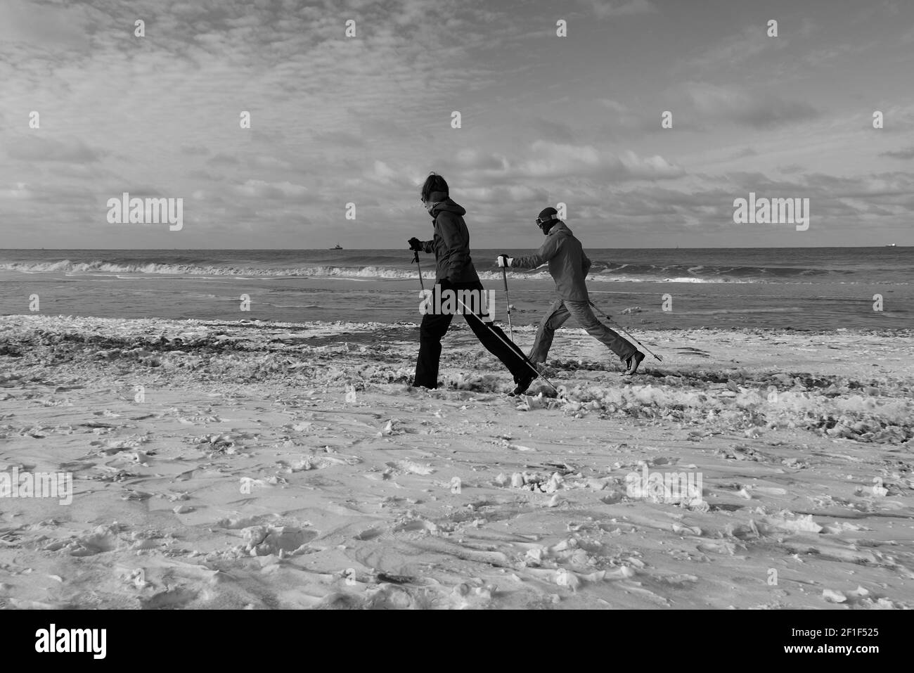 Two people ski on the beach after heavy snowfall in the country. Stock Photo
