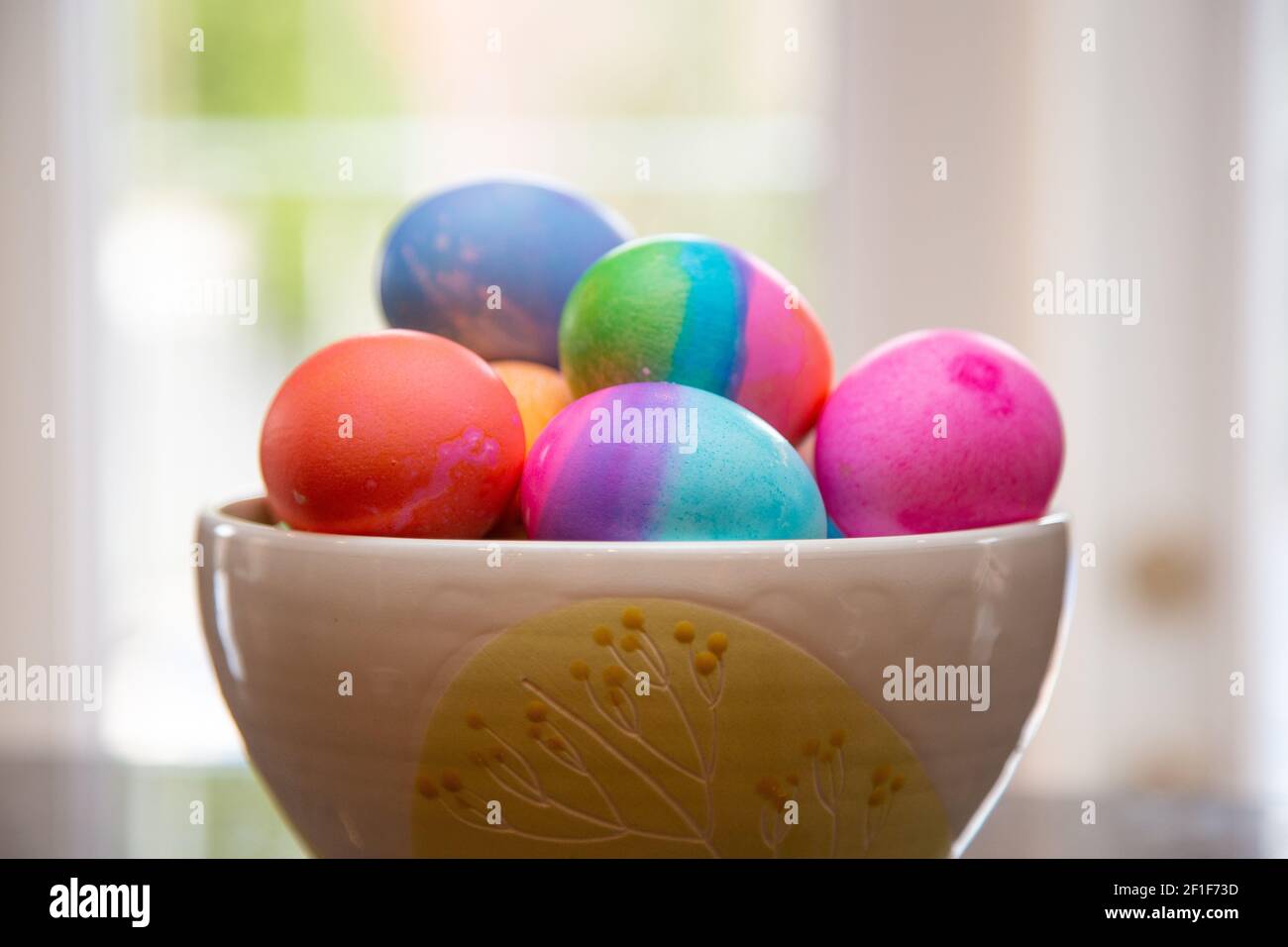 Bowl of brightly colored Easter eggs on diplay Stock Photo