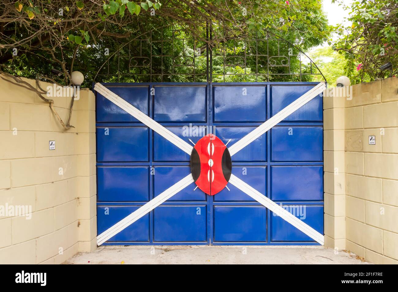 Iron gate with a white cross and a shield in a village near the town of Gede in Kenya Stock Photo